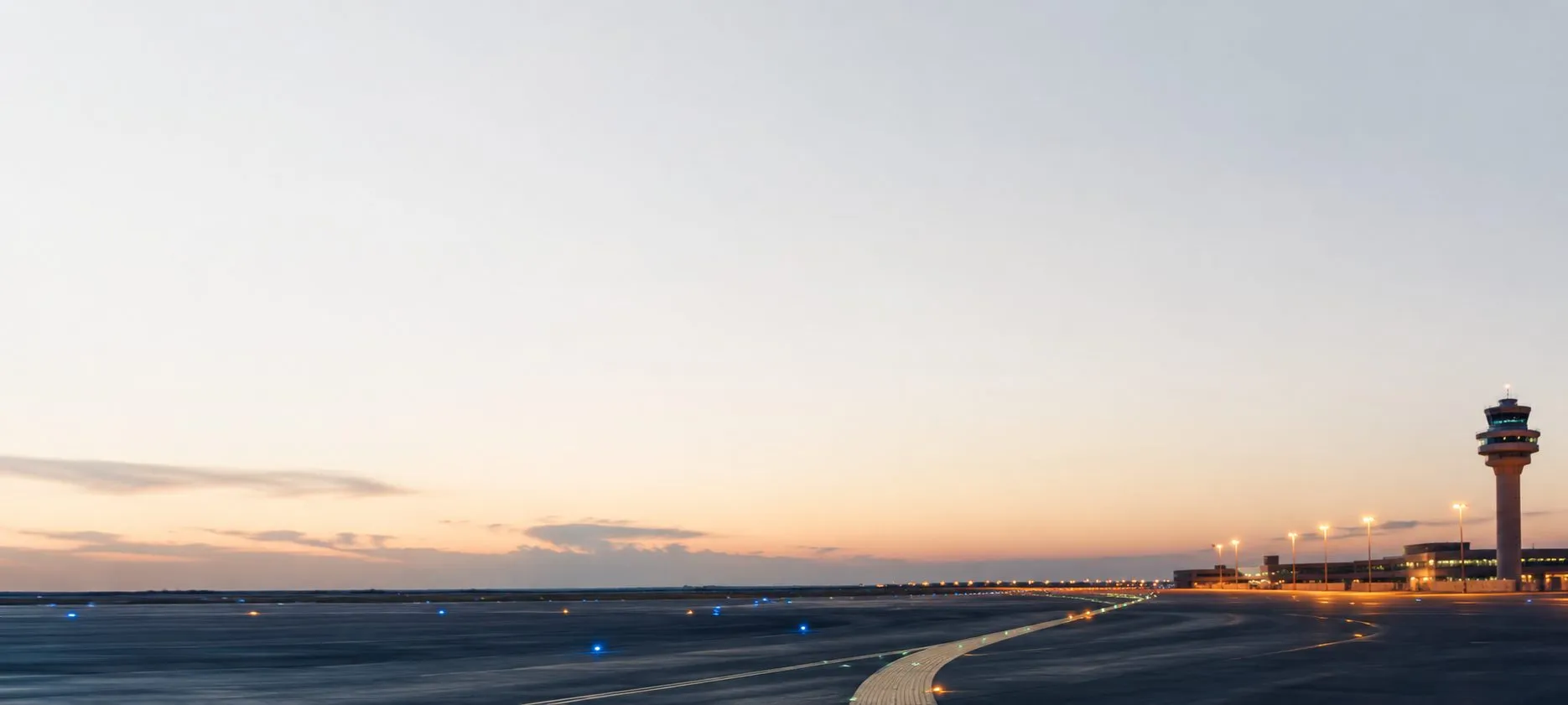 Taxiway lead-on lights curving towards the control tower at dusk